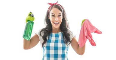 verrast jong meisje gekleed in huishouding kleren Holding een groen wasmiddel en een roze schoonmaak vel foto