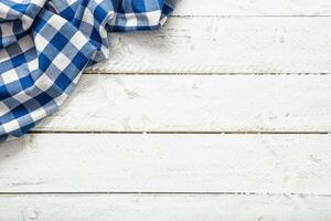 blauw geruit keuken tafelkleed Aan houten tafel. foto