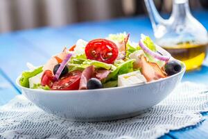 salade. vers zomer sla salade.gezond middellandse Zee salade olijven tomaten Parmezaanse kaas kaas en prosciutto foto