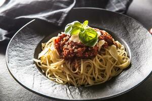 dichtbij omhoog Italiaans spaghetti bolognese in zwart bord foto