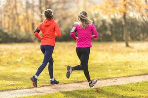 twee jong geschiktheid Dames rennen in de herfst park foto