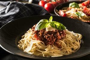 dichtbij omhoog Italiaans spaghetti bolognese in zwart bord foto