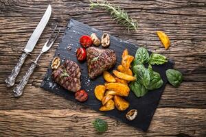 gegrild rundvlees steak met rozemarijn, zout en peper Aan oud snijdend bord. rundvlees lende steak. foto