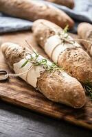 volkoren vers gebakken knapperig stokbrood Aan een houten bord foto