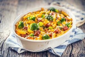 gebakken pasta penne met broccoli gerookt varkensvlees nek mozzarela kaas en anders ingrediënten foto