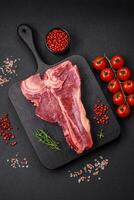 rauw vers sappig rundvlees t-bone steak met zout, specerijen en kruiden foto