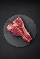 rauw vers sappig rundvlees t-bone steak met zout, specerijen en kruiden foto