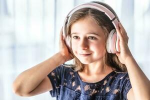 een klein kind luistert naar muziek- door draadloze hoofdtelefoons foto