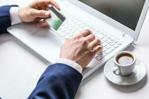 Mens handen typen Aan de toetsenbord van laptop Holding credit kaart, detailopname van online boodschappen doen foto
