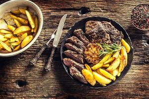 gegrild rundvlees rib oog steak met knoflook Amerikaans aardappelen rozemarijn zout en specerijen foto