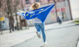 aantrekkelijk gelukkig jong meisje met de vlag van de Europese unie foto