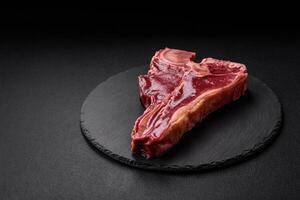 rauw vers sappig rundvlees t-bone steak met zout, specerijen en kruiden foto