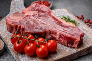 rauw vers sappig rundvlees t-bone steak met zout, specerijen en kruiden foto