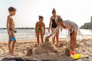 familie Aan vakantie spelen met zand kastelen Aan de strand Bij zonsondergang foto