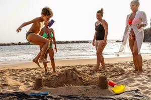 familie Aan vakantie spelen met zand kastelen Aan de strand Bij zonsondergang foto