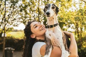 mooi vrouw instructeur knuffels haar hond gedurende een opleiding breken foto