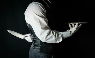 butler of ober met portie dienblad en Holding scherp mes achter rug. concept van butler deed het. klassiek moord mysterie. foto