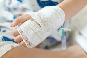 dichtbij omhoog kind hand- met zoutoplossing iv oplossing in ziekenhuis foto