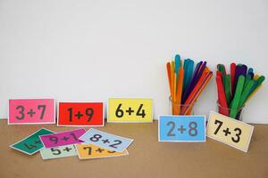 kleurrijk kaarten met getallen plus , toevoeging Aan kaarten en kleurrijk stokjes voor tellen voor kinderen. concept, onderwijs hulp, materialen voor wiskunde onderwerp. onderwijs. foto