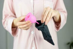 detailopname van een vrouw handen Holding een siliconen menstruatie- beker. alternatief ecologisch vrouwelijk hygiëne Product gedurende menstruatie afvalvrij concept foto