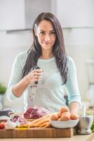 vrolijk vrouw koken in keuken met vreugde en scherp mes voorbereidingen treffen lunch foto