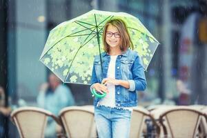 portret van mooi jong pre-tiener meisje met paraplu onder ra foto