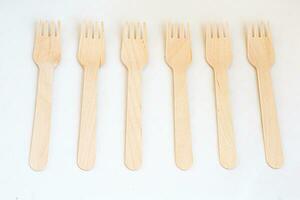 beschikbaar eco vriendelijk houten vorken Aan wit achtergrond. eco vriendelijk beschikbaar houten bestek Aan wit achtergrond. foto