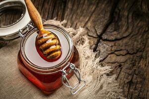 pot van honing met beer Aan houten tafel - detailopname foto
