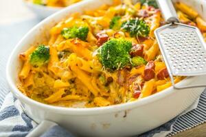 gebakken pasta penne met broccoli gerookt varkensvlees nek mozzarela kaas en anders ingrediënten foto