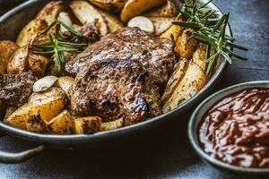 rundvlees gegrild steaks met barbecue saus geroosterd aardappelen en rozemarijn foto