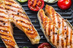 Zalm. gegrild vis Zalm. gegrild Zalm steak in rooster pan Aan rustiek houten tafel foto