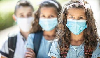 portret van schoolkinderen met gezicht maskers gedurende covid-19 quarantaine foto