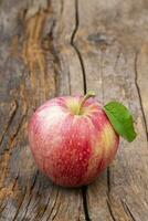 detailopname van een appel Aan een oud hout bord foto