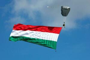 parachutist vliegend in de lucht. extreem sport en x Games. jumping met Hongaars vlag. foto