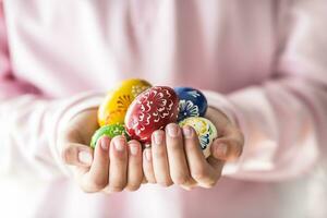 detailopname veelkleurig Pasen eieren in de meisjes handen foto