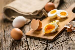 detailopname gekookt of rauw kip eieren Aan houten bord foto