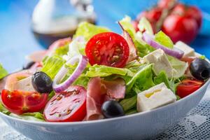 salade. vers zomer sla salade.gezond middellandse Zee salade olijven tomaten Parmezaanse kaas kaas en prosciutto foto