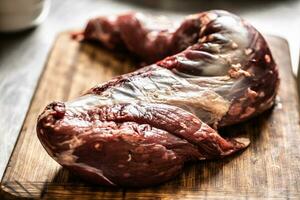 een groot stuk van rauw rundvlees entrecote Aan houten bureau foto