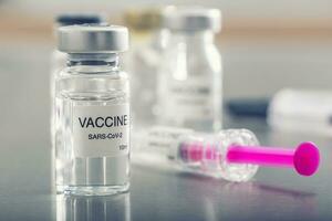 covid-19 coronavirus vaccin in een ampul met injectiespuit klaar voor vaccinatie foto