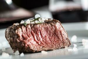 rundvlees lende steak Aan wit bord en rood wijn in kroeg of restaurant foto