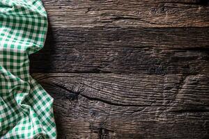 groen geruit keuken tafelkleed Aan rustiek houten tafel foto
