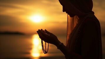 moslim vrouw gebruik makend van kralen naar bidden Bij zonsopkomst buiten. silhouet concept foto