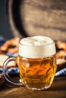 oktoberfeest bier met zoute krakeling houten vat en blauw tafelkleed foto