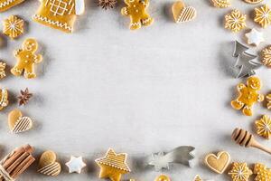 Kerstmis peperkoek koekjes liggen Aan de tafel samen met kaneel en pijnboom kegels. foto