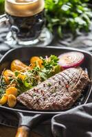 rundvlees flank steak in rooster pan met zute aardappel puree knoflook kruid decoratie en droogte bier foto