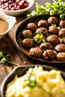 Zweeds voedsel kottbullar gehaktballen, geserveerd in een pan met gepureerd aardappelen, peterselie en veenbes saus foto