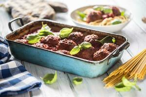 heerlijk Italiaans maaltijd vlees rundvlees ballen met pasta spaghetti en basilicum in wijnoogst brander pan foto