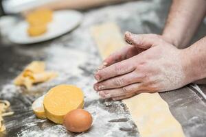 chef-kok handen bereidt zich voor Italiaans voedsel gevuld pasta ravioli foto