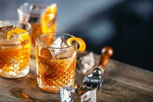 oud fashioned rum drinken Aan ijs met oranje schil garneer foto