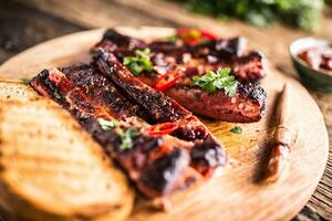 smakelijk barbecue gegrild varkensvlees ribben met Chili pepers en peterselie kruiden. foto